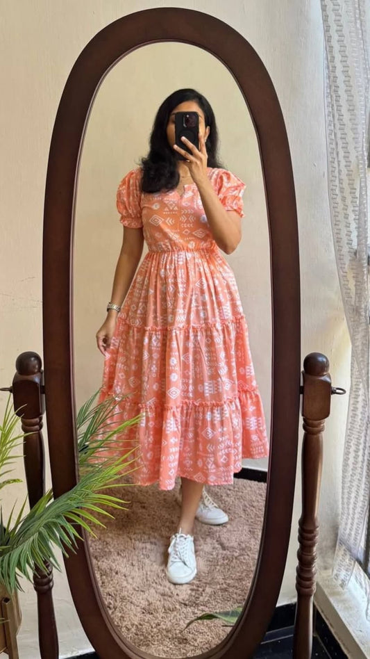 Woman in a pink dress standing in front of a full-length mirror.