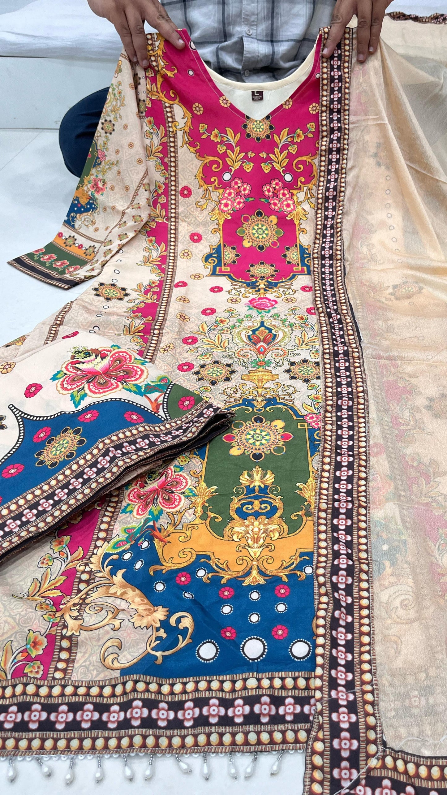Colorful embroidered fabric with intricate patterns on a neutral background